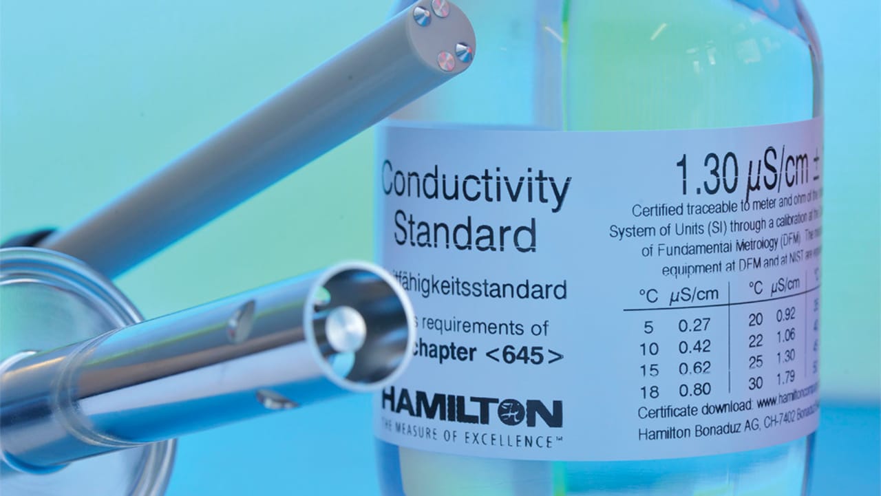 Hamilton Conductivity Standard bottle labeled 1.30 µS/cm with conductivity sensors in the foreground