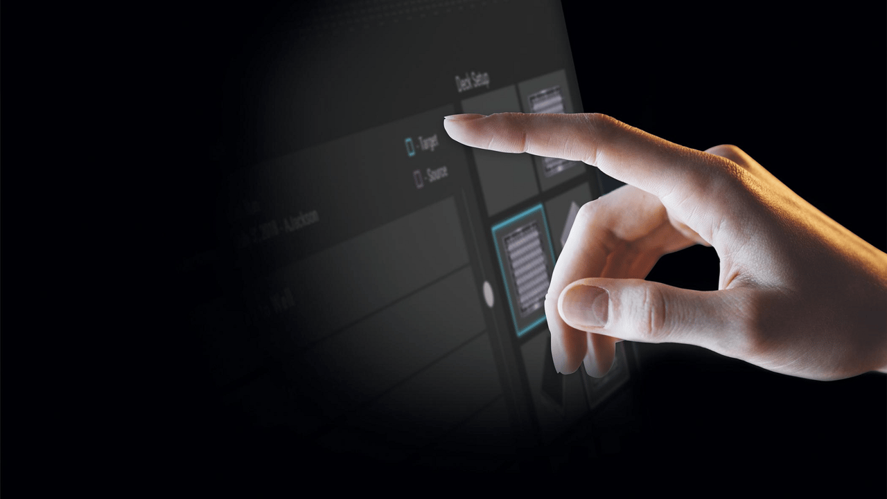 Hand touching a dark touchscreen interface displaying a "Deck Setup" menu with Target and Source options