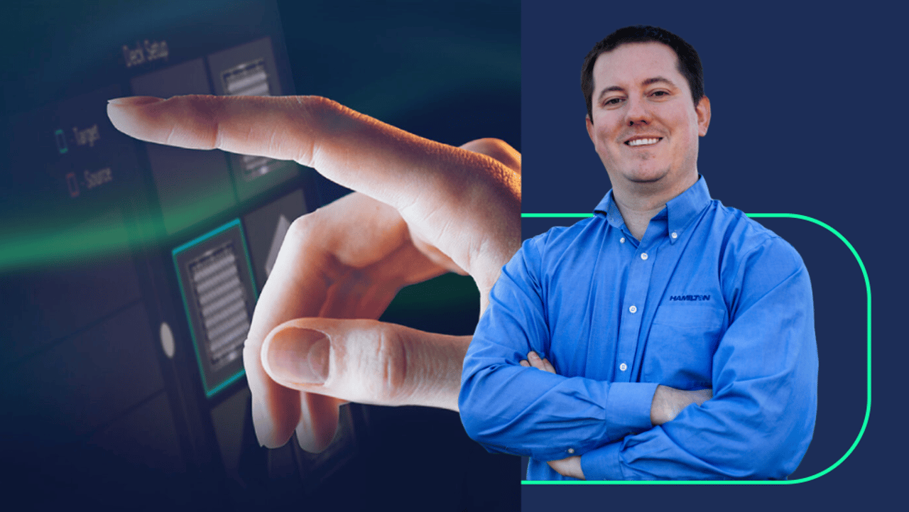Hamilton employee in a blue shirt with arms crossed, beside a hand touching a dark touchscreen interface
