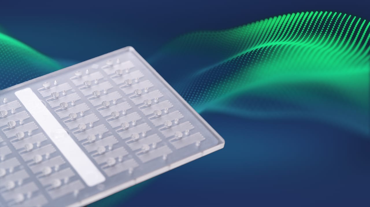 Translucent microplate with raised circular ports and channel features against a blue background with green digital wave
