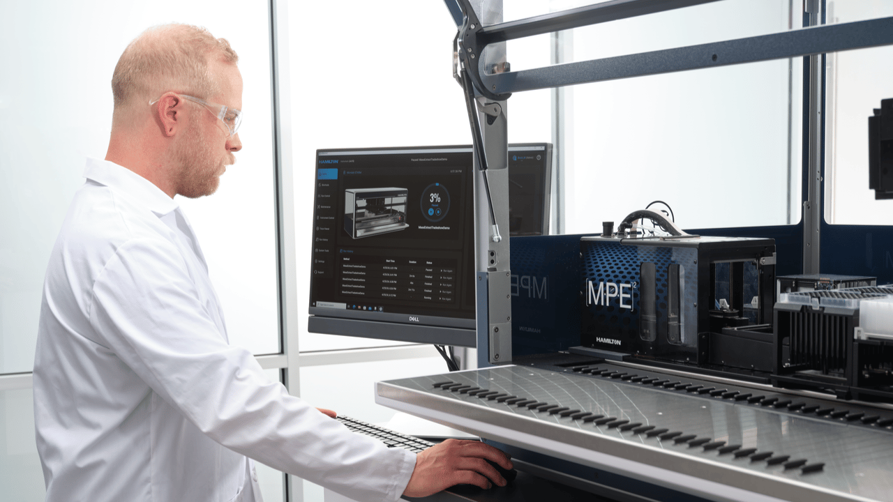 Lab technician programing a liquid handler with VENUS software.