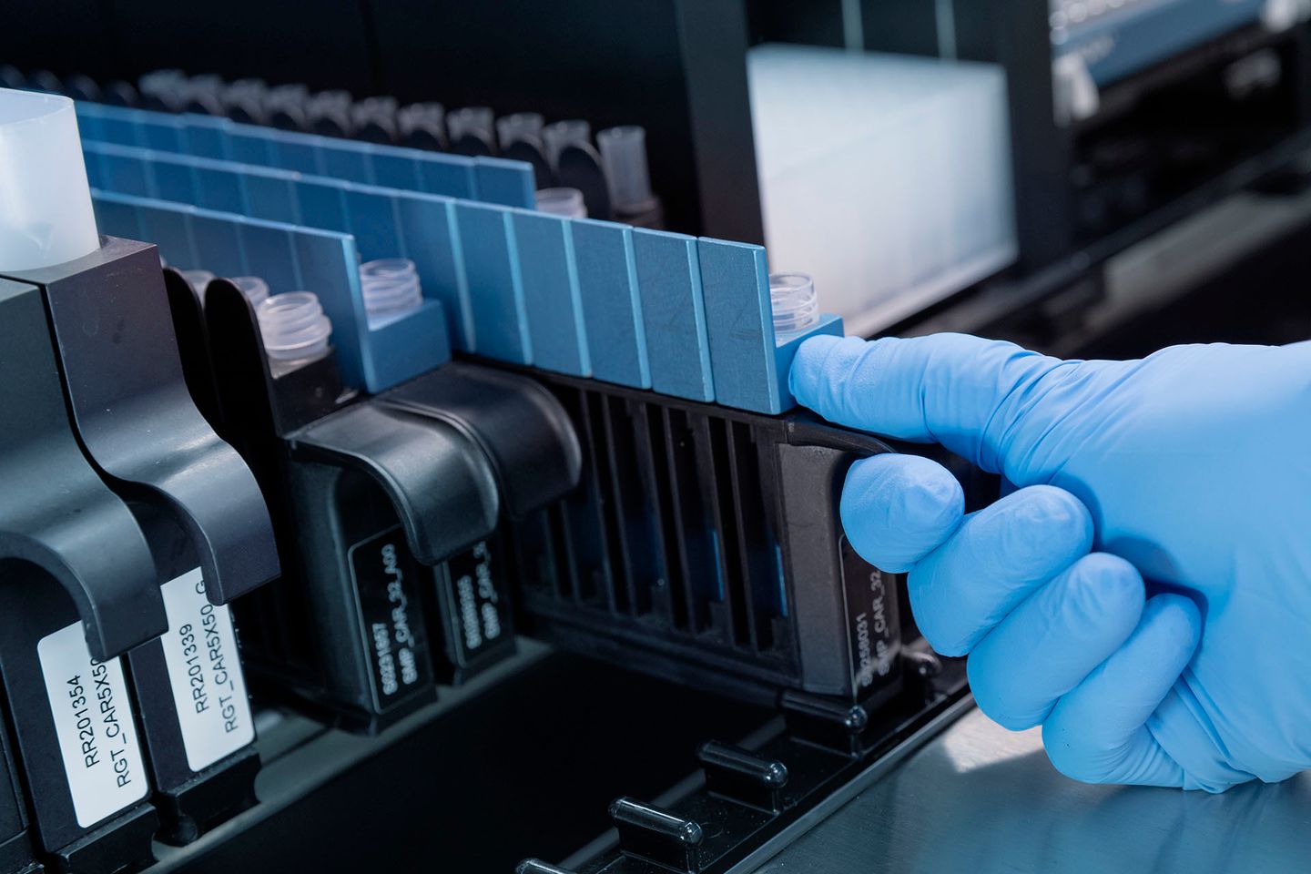 A scientist handling sample trays in an automation lab