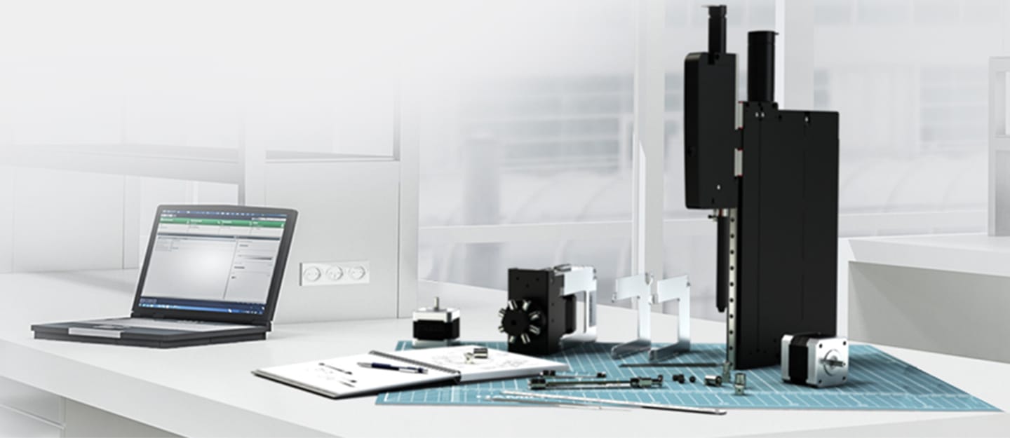 Laptop with software interface beside a modular liquid handling assembly with linear stage, stepper motors, and components on a lab bench