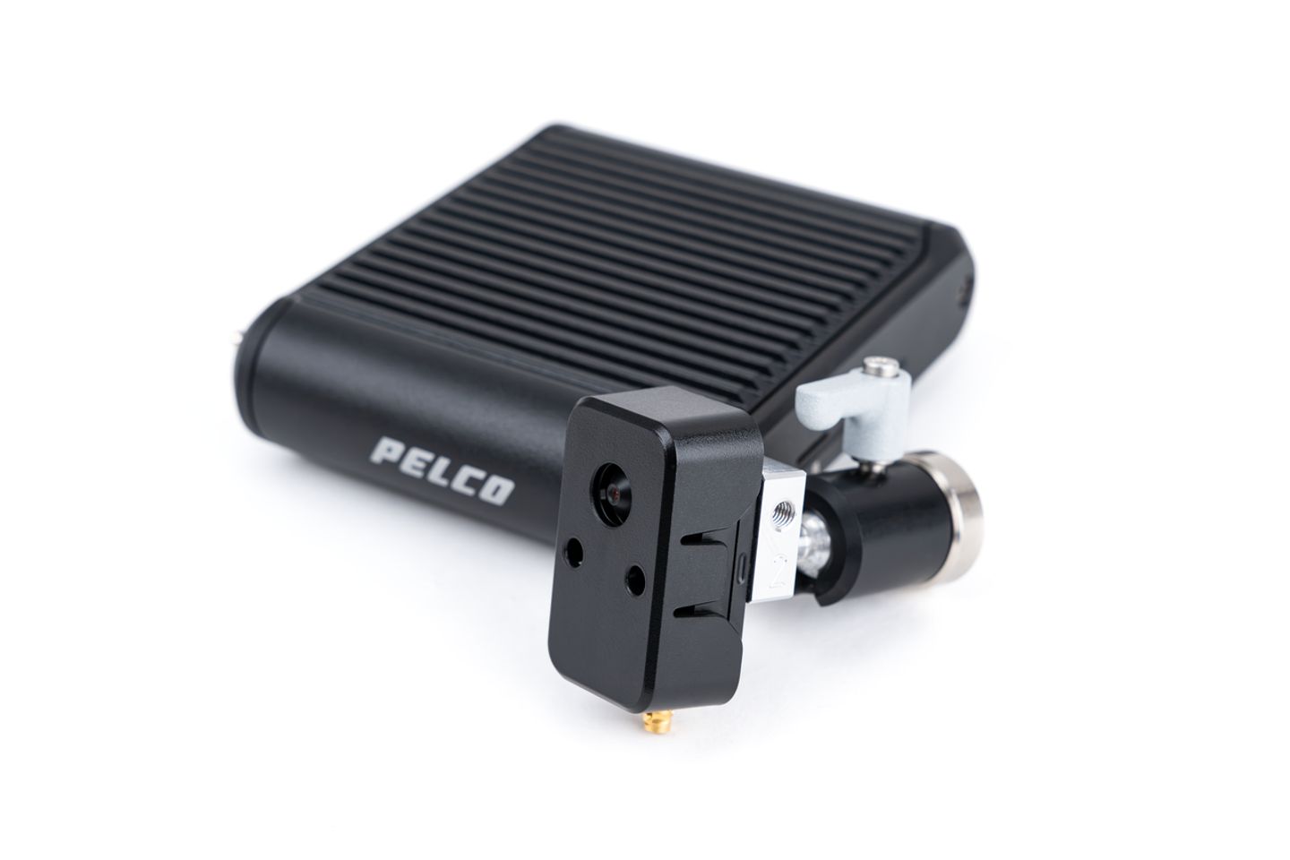 Pelco-branded black aluminum enclosure with ribbed heat sink and attached compact camera module with lens, mounted via adjustable bracket