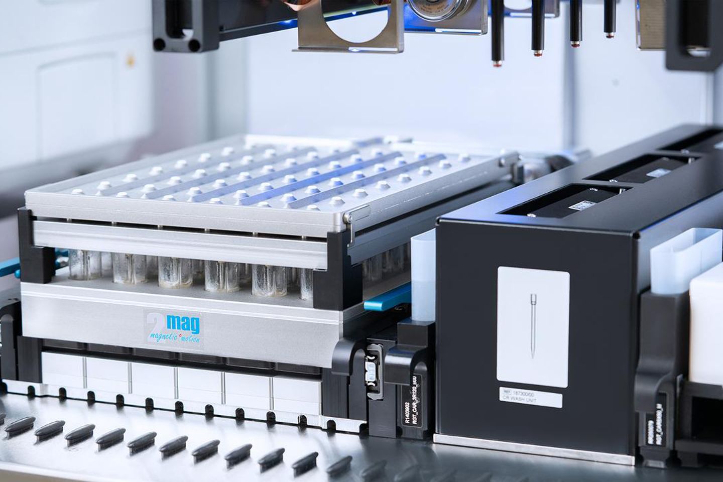2mag magnetic motion bioreactor block with sample tubes beneath a microplate, next to a CR Wash Unit module