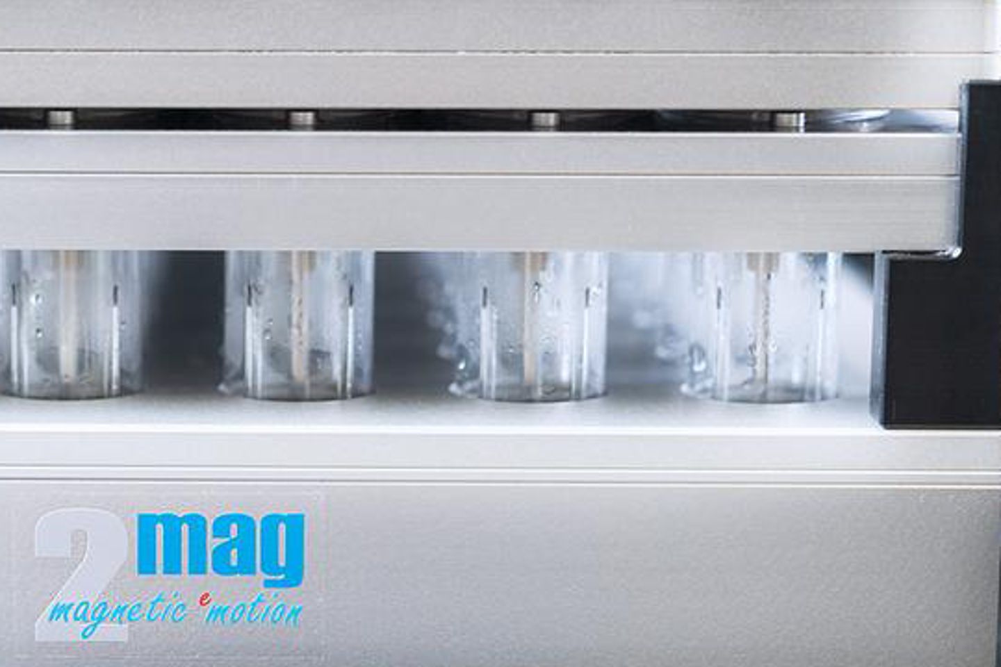 Row of cylindrical bioreactor vessels in a 2mag magnetic motion system, with active stirring visible