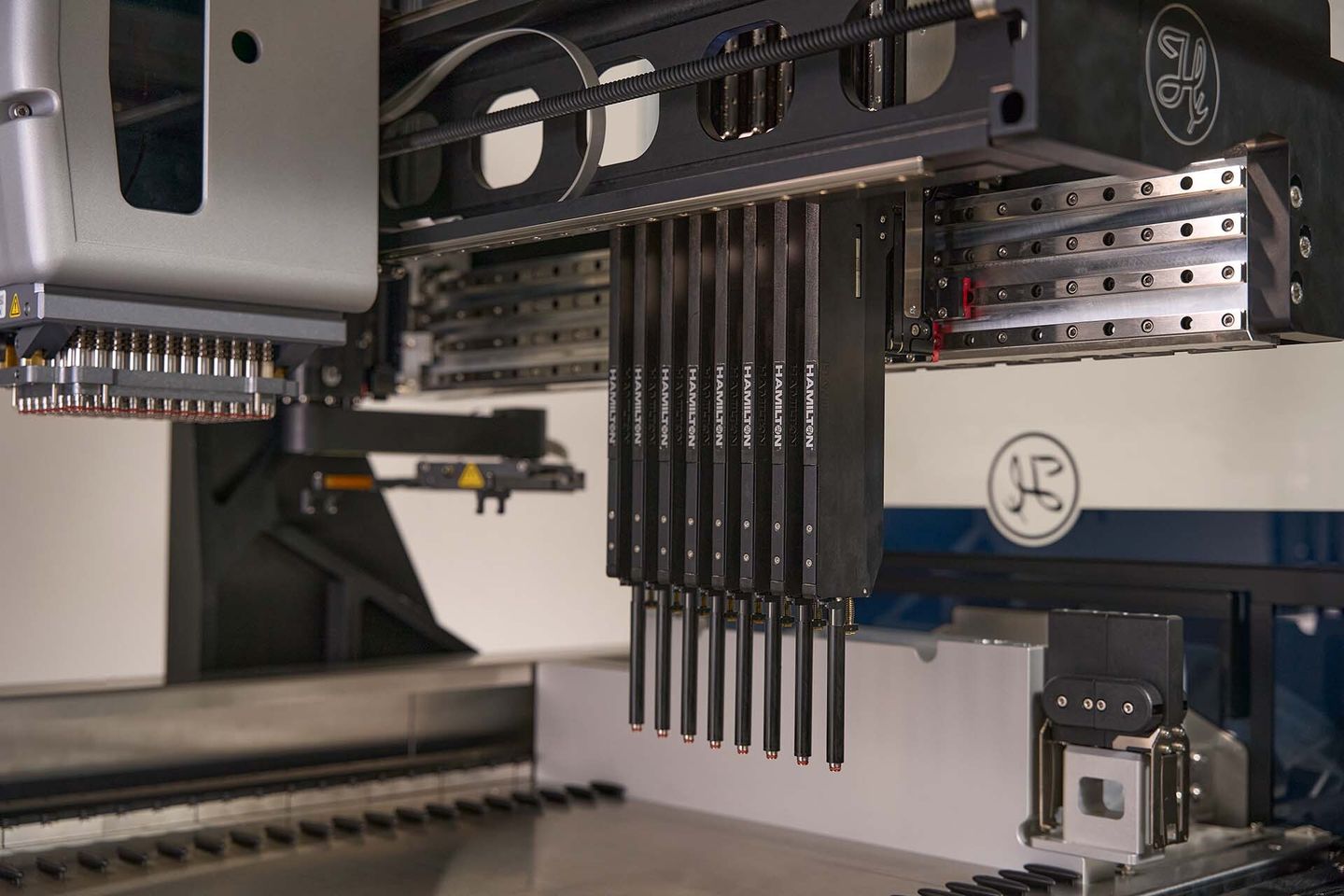Hamilton automated liquid handler deck with multiple CO-RE pipetting channels and an 8-channel pipetting arm mounted on gantry rails