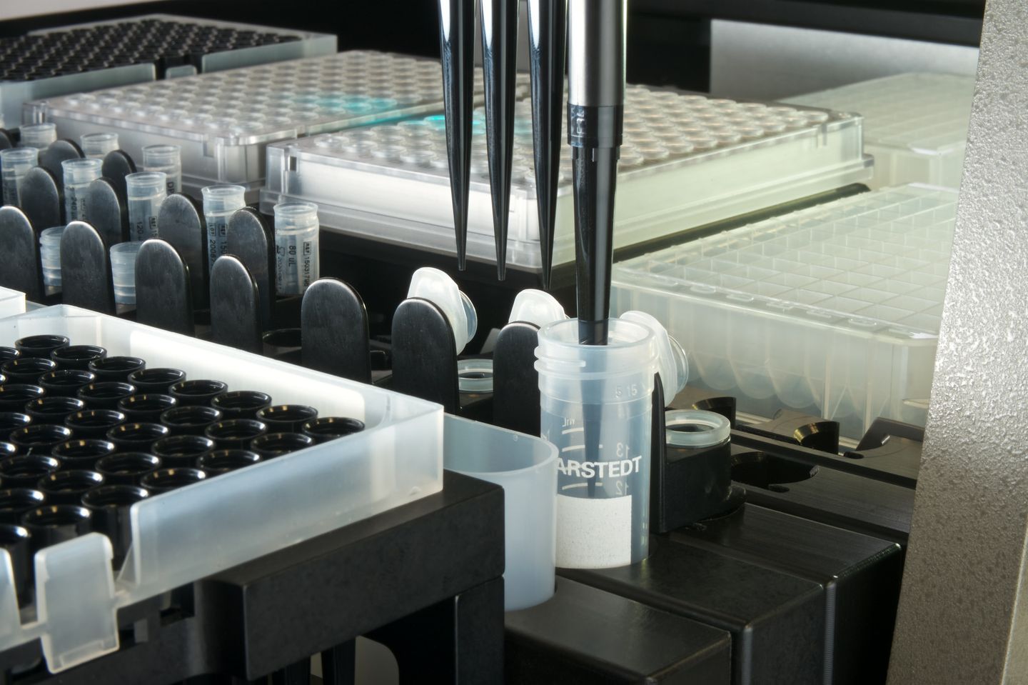Automated liquid handler with multi-channel pipette head dispensing into Sarstedt tubes on a deck with microplates and sample racks