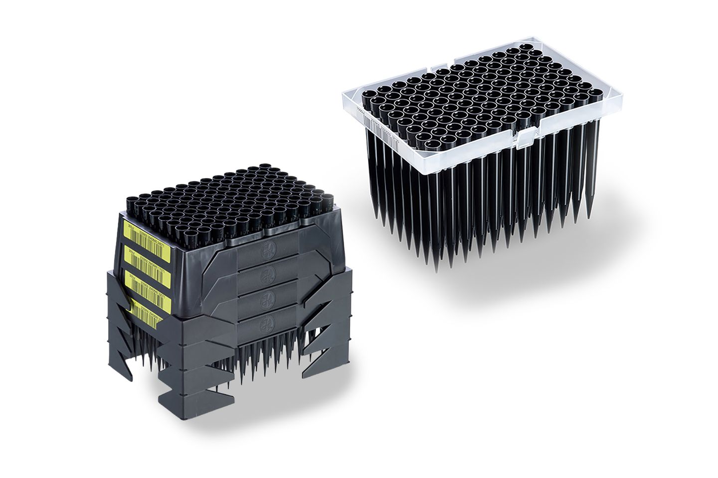 Two racks of black pipette tips: a stacked dark gray rack with yellow barcodes, and a clear tray rack.