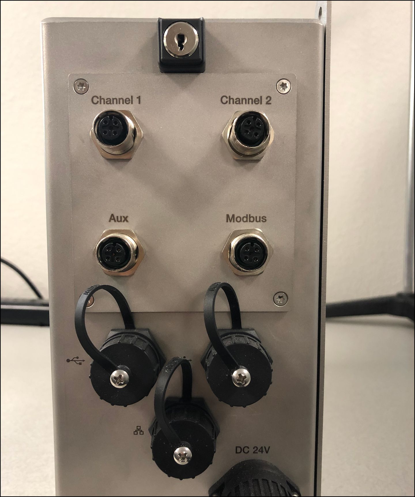 Panel with Channel 1, Channel 2, Aux, Modbus connectors, USB, Ethernet, and DC 24V ports with a key switch