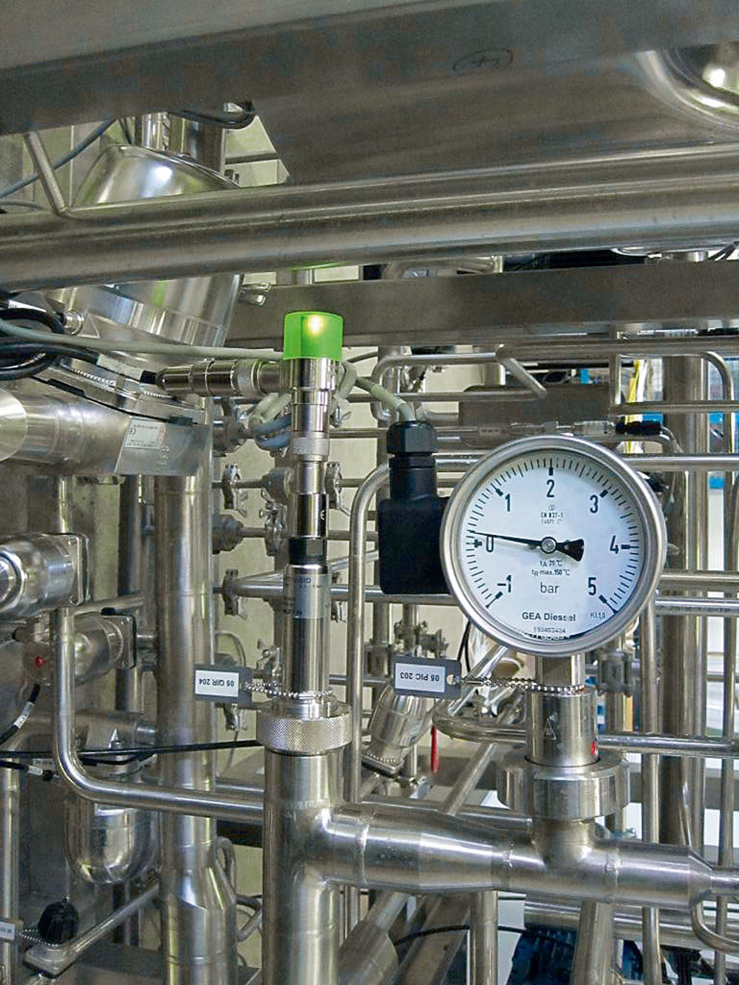 Stainless steel process piping with a GEA Diessel pressure gauge and a sensor with green indicator light