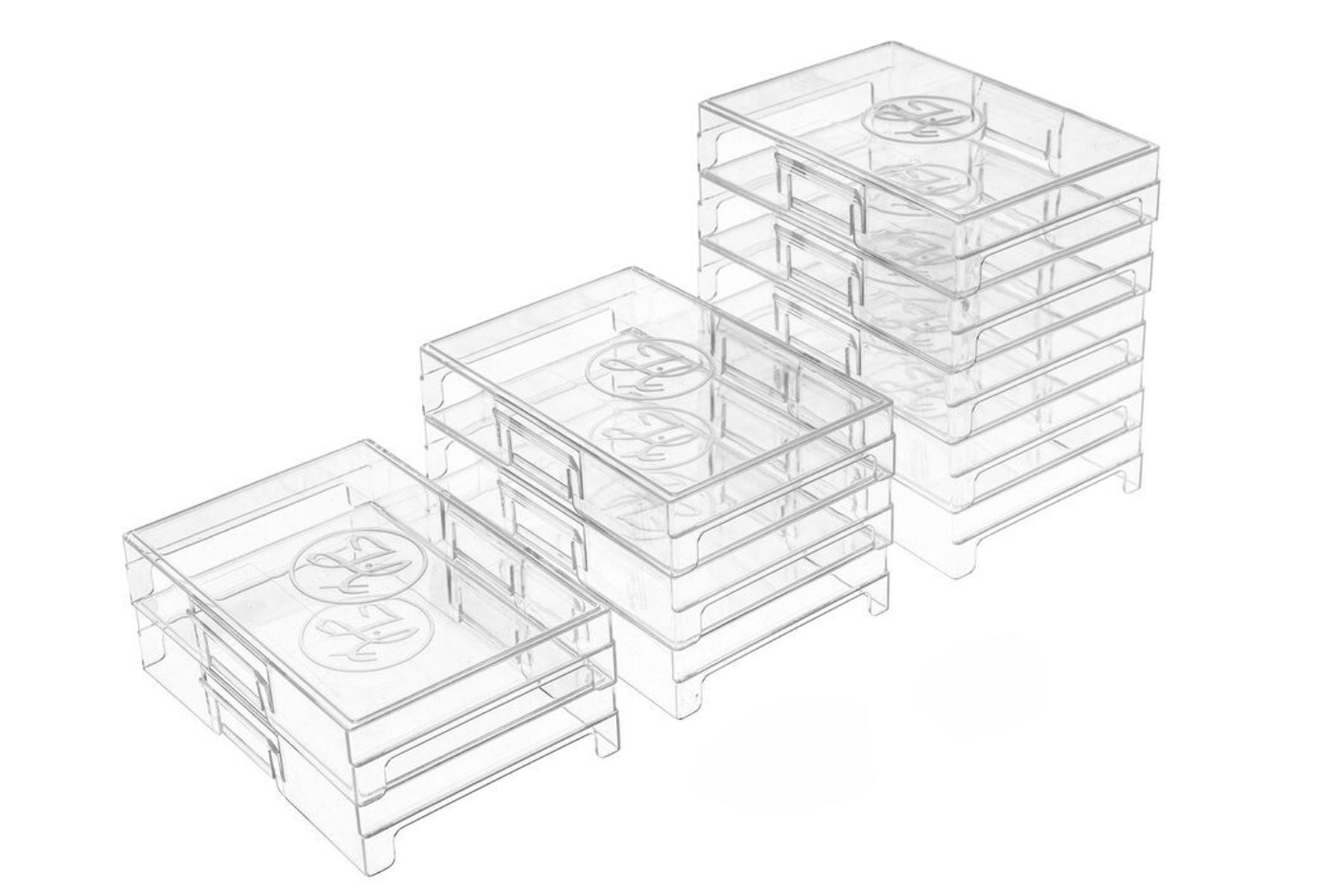 Three stacks of clear plastic storage trays arranged in ascending heights, each with circular embossed lids