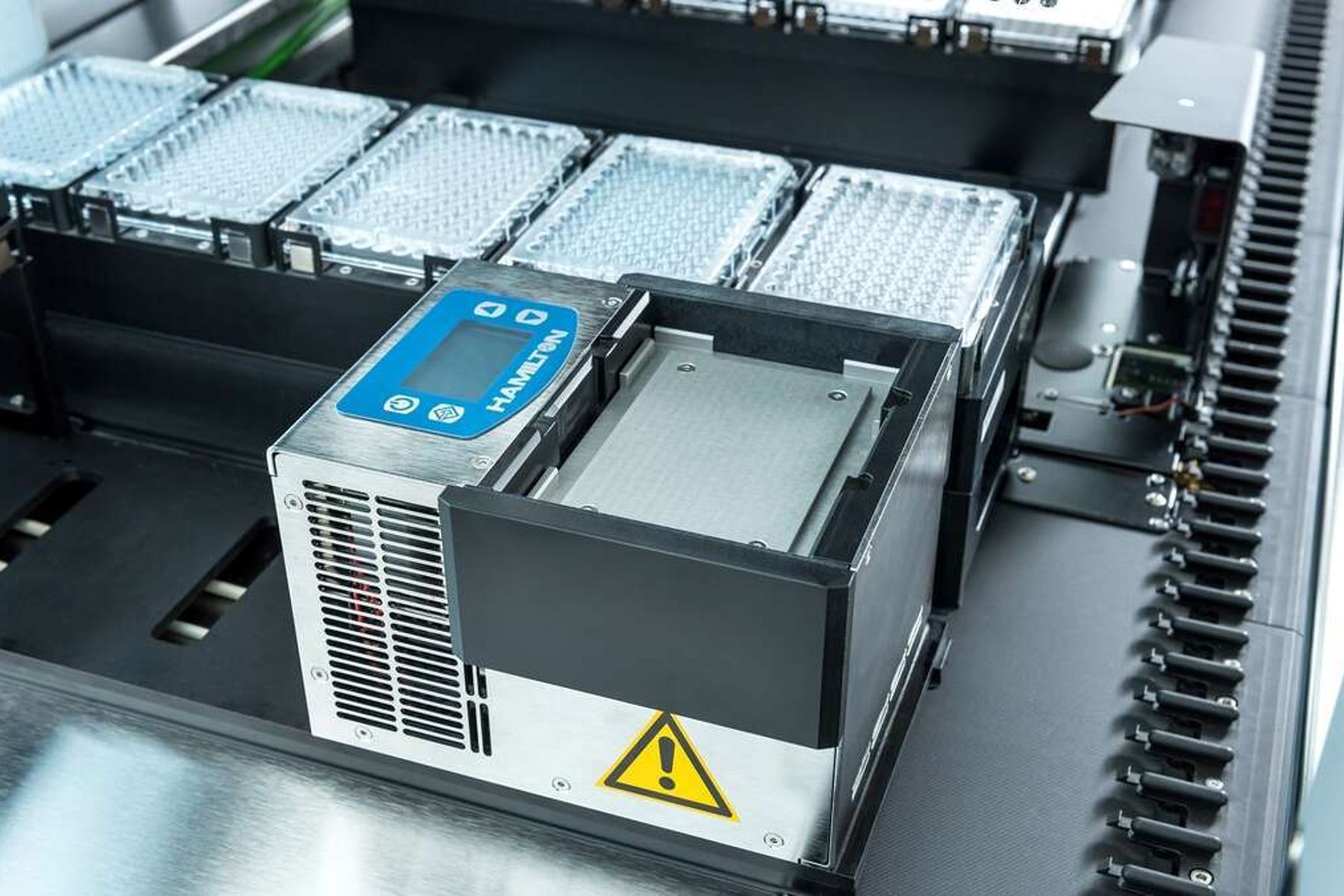 Hamilton-branded heating/cooling module on a liquid handler deck with microplates visible nearby