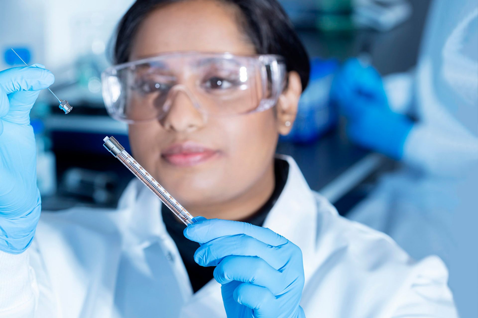 Hamilton Lab Scientist Looking at Syringe