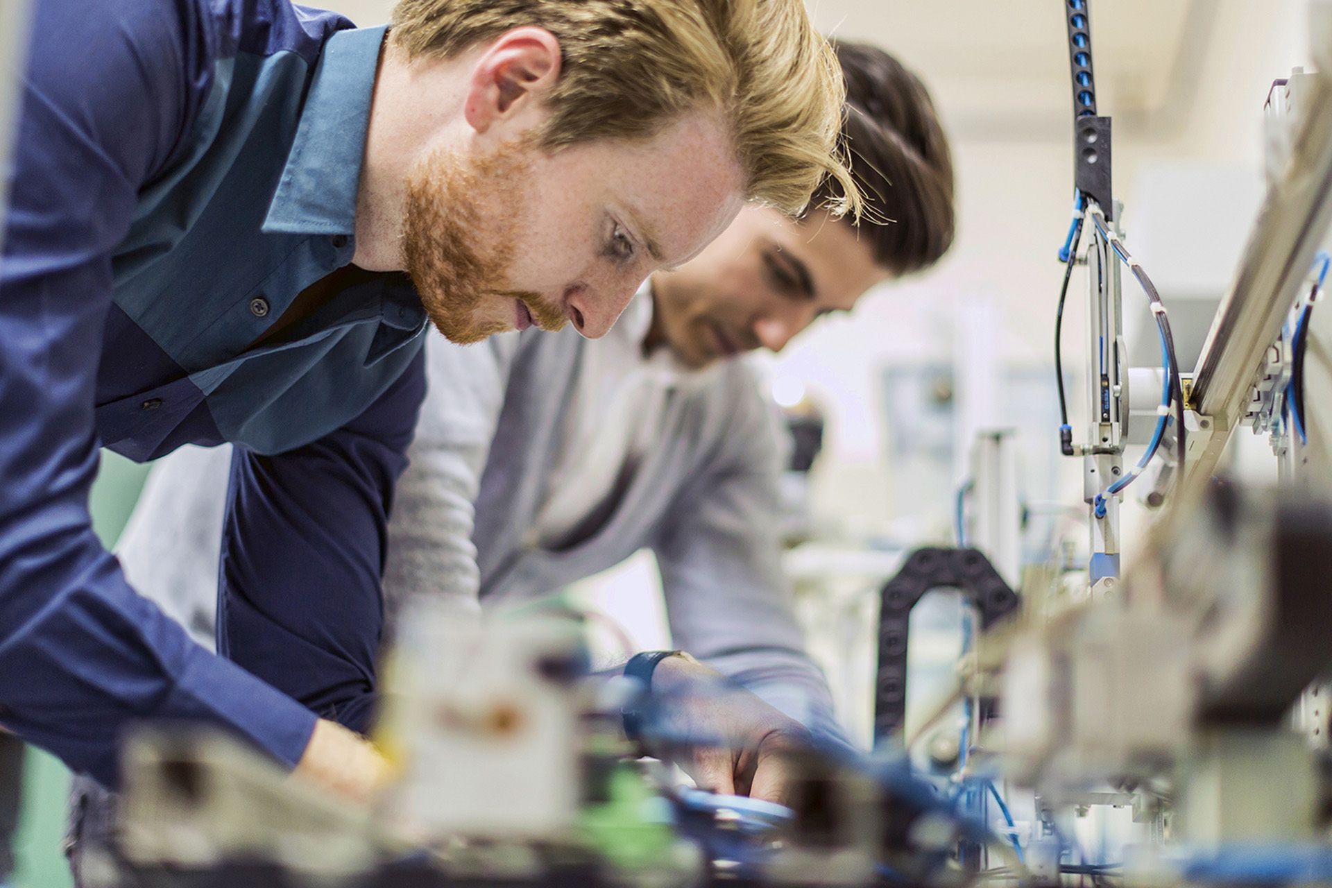 Team members performing hands-on equipment training in a lab setting.