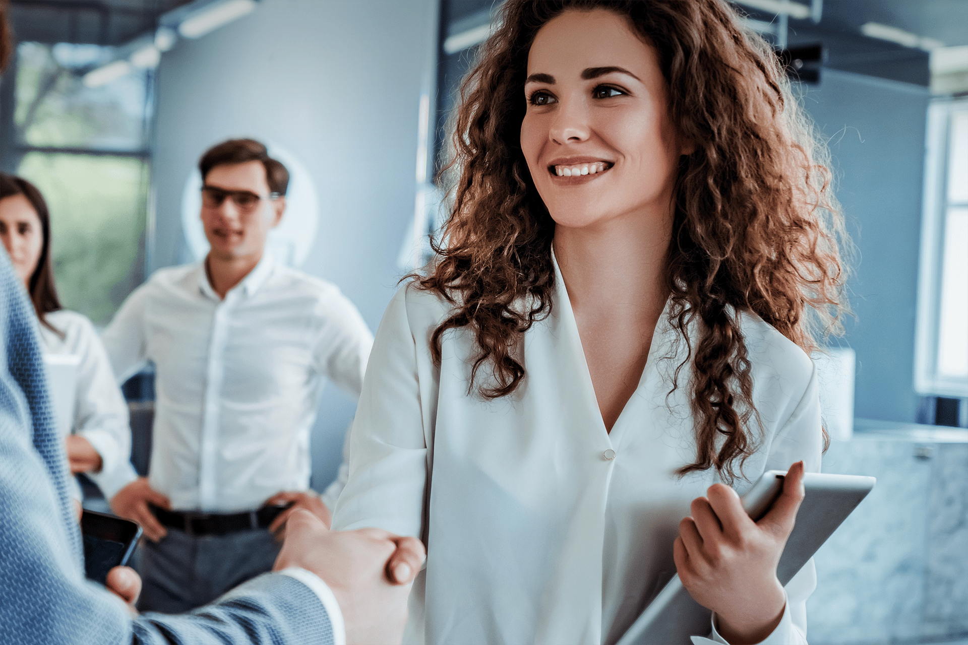 A woman shakes a man's hand during a business meeting.