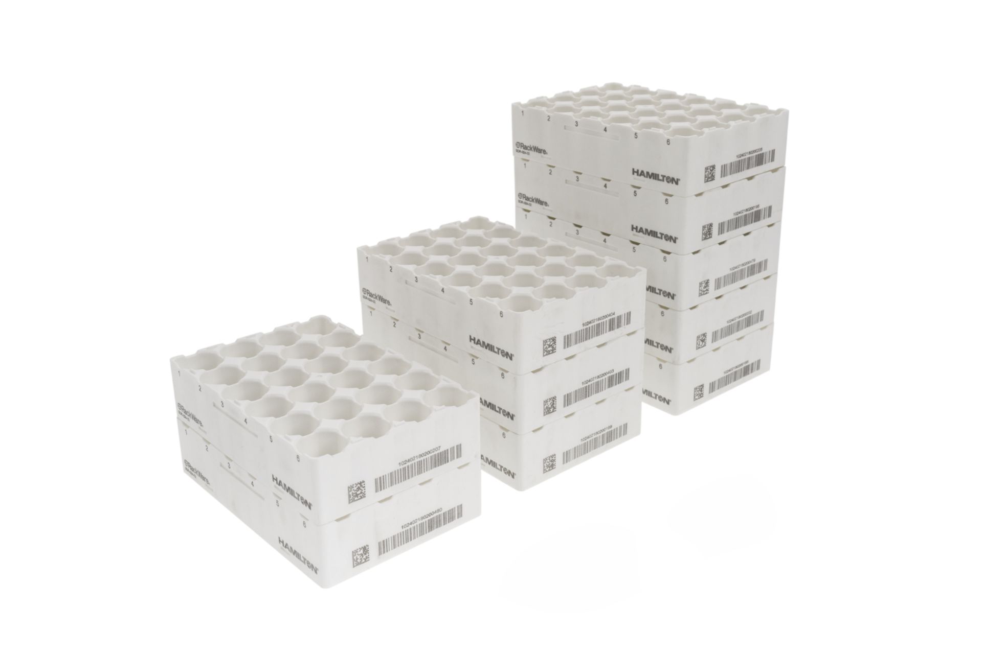 Three stacks of white Hamilton RackWare sample tube racks with hexagonal wells and barcode labels, shown in varying heights
