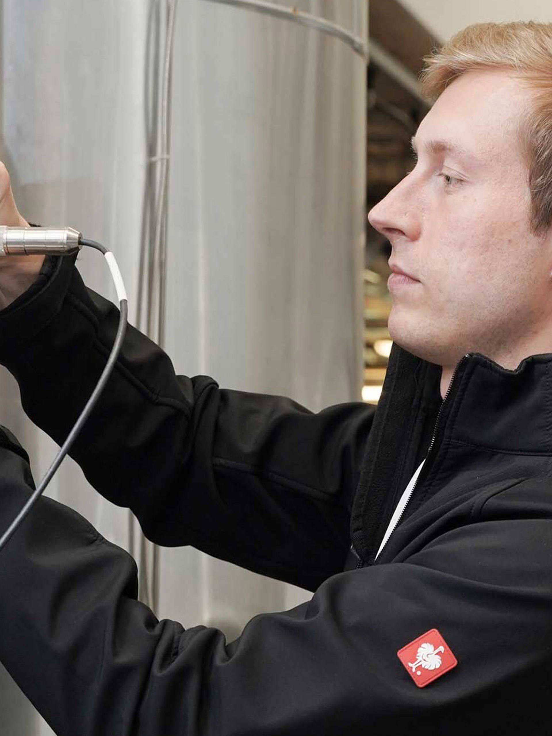 Lab technician installing sensor to fermenter