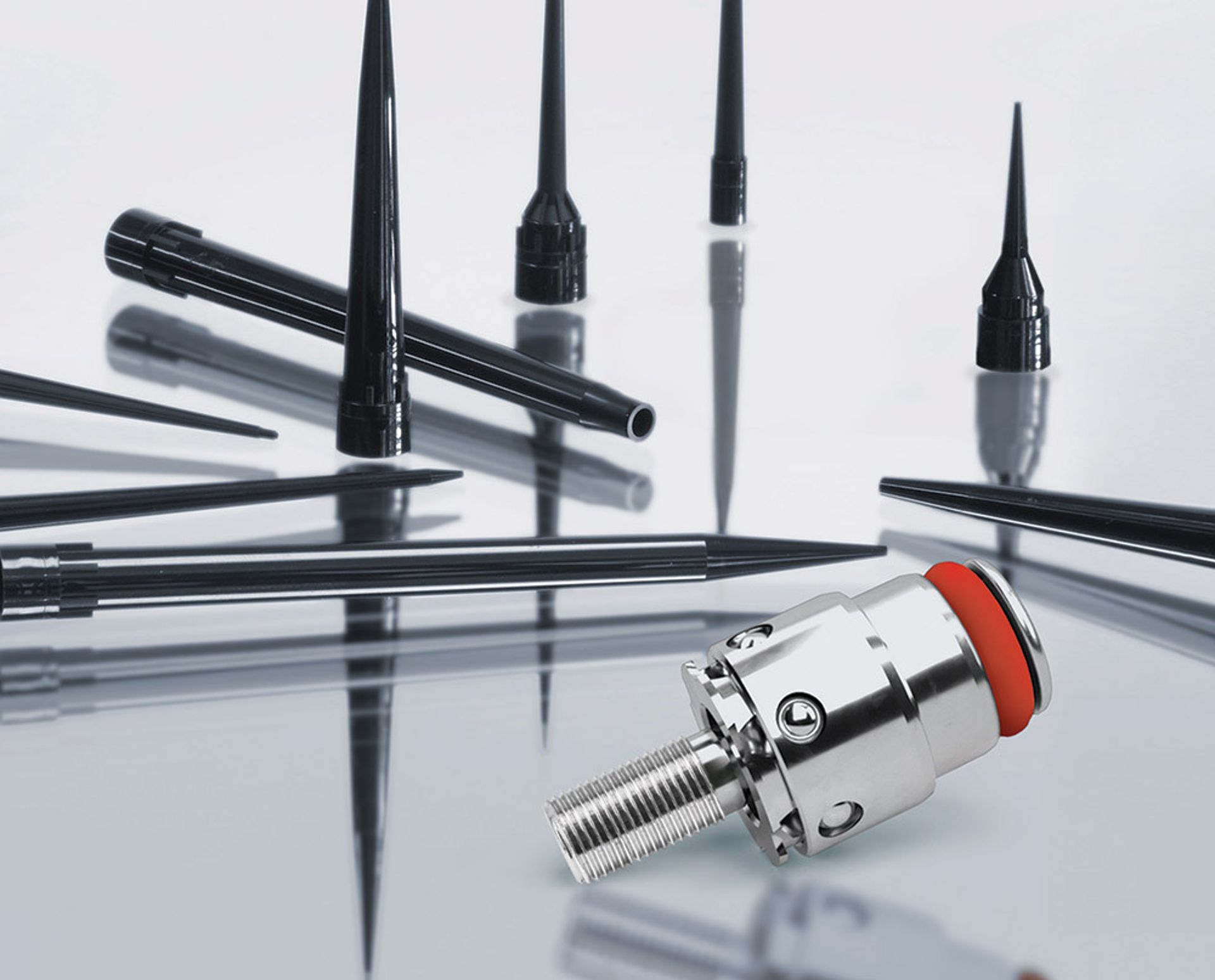 Assorted black pipetting needles and tips of varying sizes with a chrome quick-connect fitting with red seal