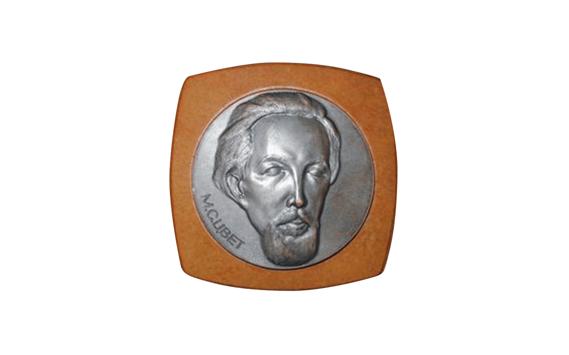 Metal relief medallion mounted on wood, depicting a bearded figure's portrait, signed "M. CUBET"