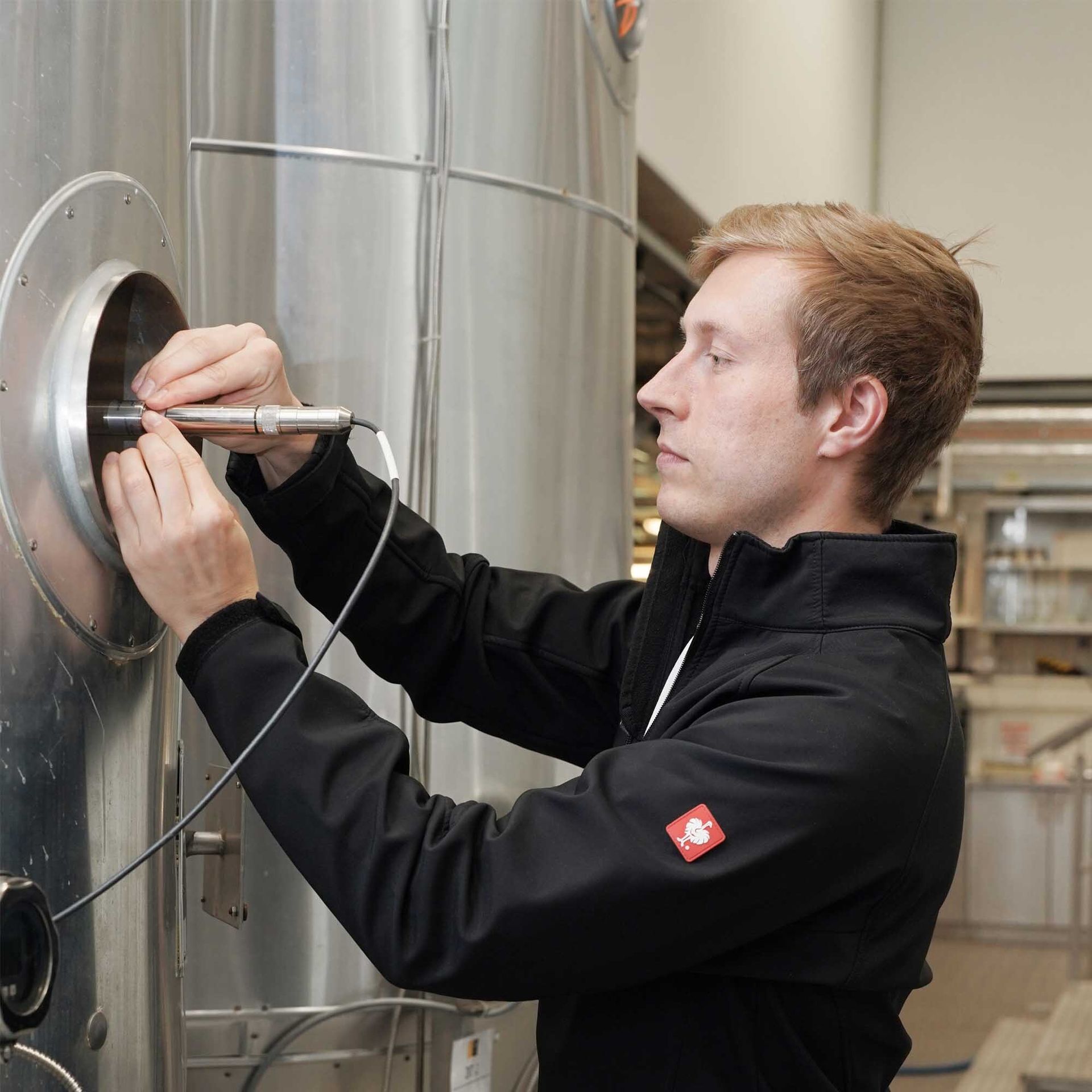 Lab technician installing sensor to reactor