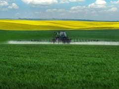 Tractor Spraying Pesticides on Crops