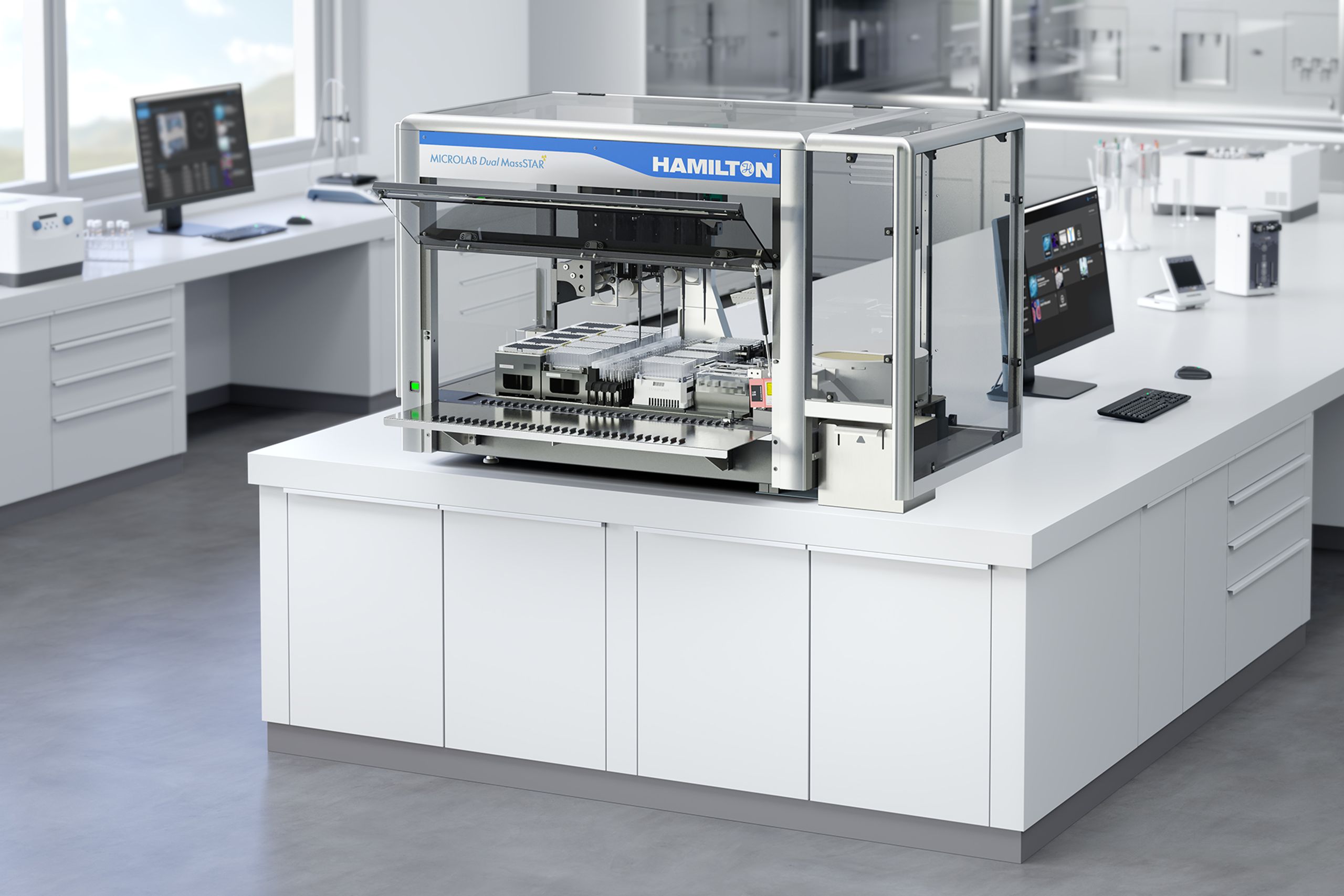 Hamilton Microlab Dual MassSTAR automated liquid handling workstation on a lab bench, with open enclosure revealing pipetting deck and a monitor to the right.