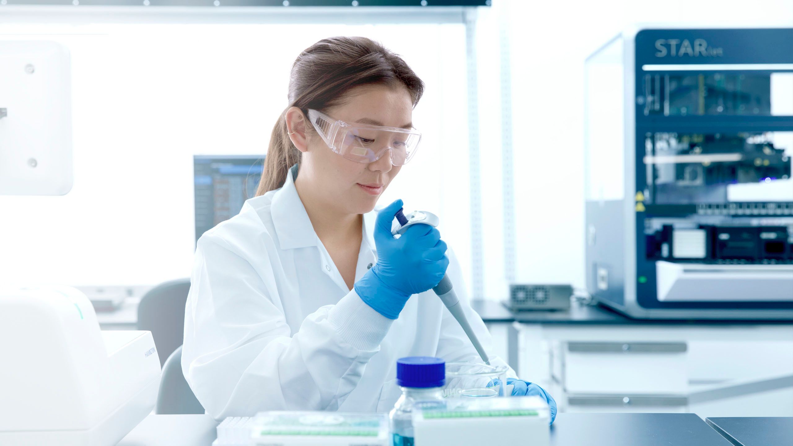 A scientist is using a Hamilton pipette