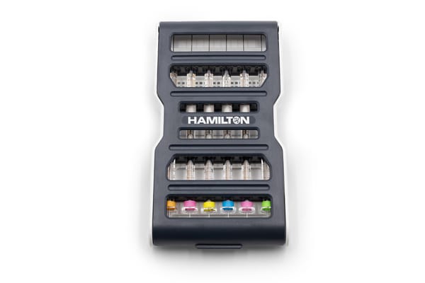 Hamilton syringe guard case holding multiple syringes and color-coded bands in yellow, pink, blue, and green