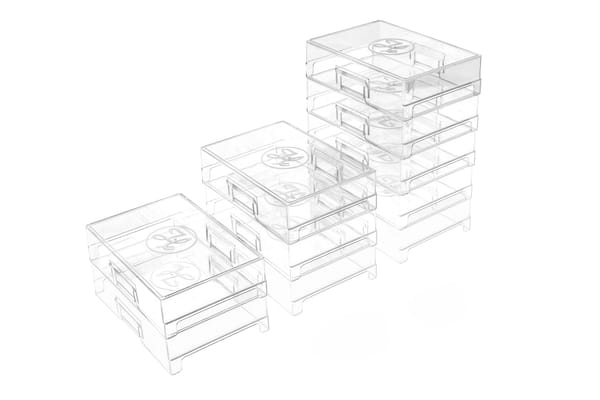 Clear stackable storage boxes arranged in a stair-step pattern, three stacks of increasing height