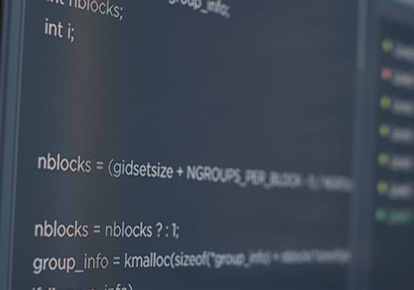 Close-up of a dark-themed code editor displaying C programming language script on a monitor