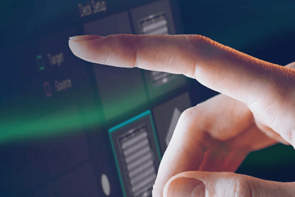 Finger pointing at a touchscreen displaying a software interface with Target and Source labels
