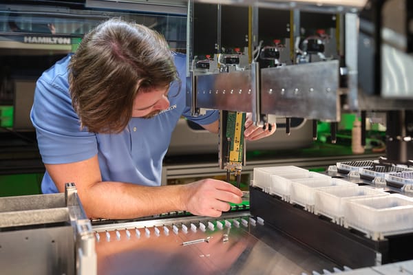 Hamilton field service engineer adjusting pipetting head components on an automated liquid handler