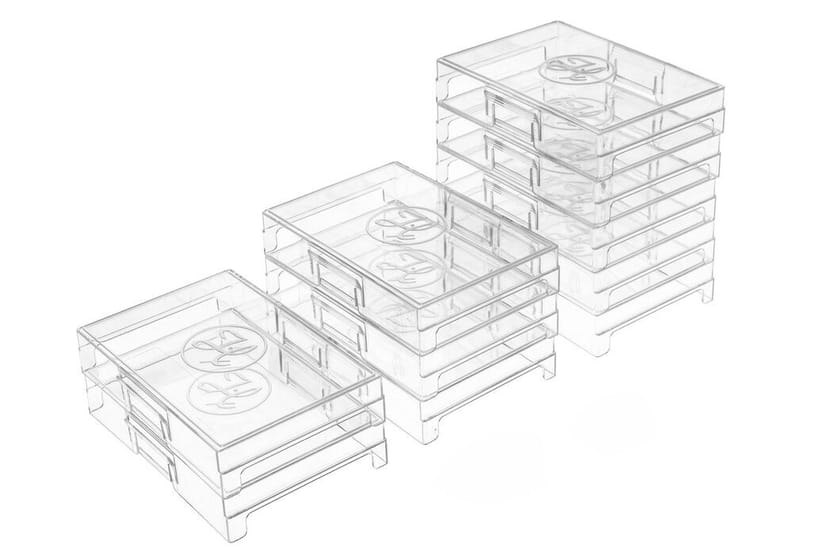Three stacks of clear plastic storage trays arranged in ascending heights, each with circular embossed lids