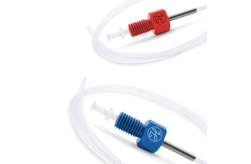 Two Hamilton fluid-handling fittings with PTFE tubing — one red, one blue — on a white background.