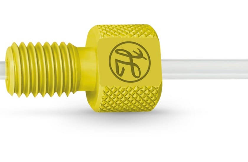 Yellow knurled flangeless fitting with threaded male end on clear tubing