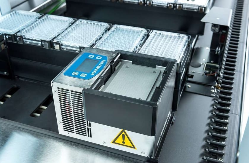 Hamilton-branded heating/cooling module on a liquid handler deck with microplates visible nearby