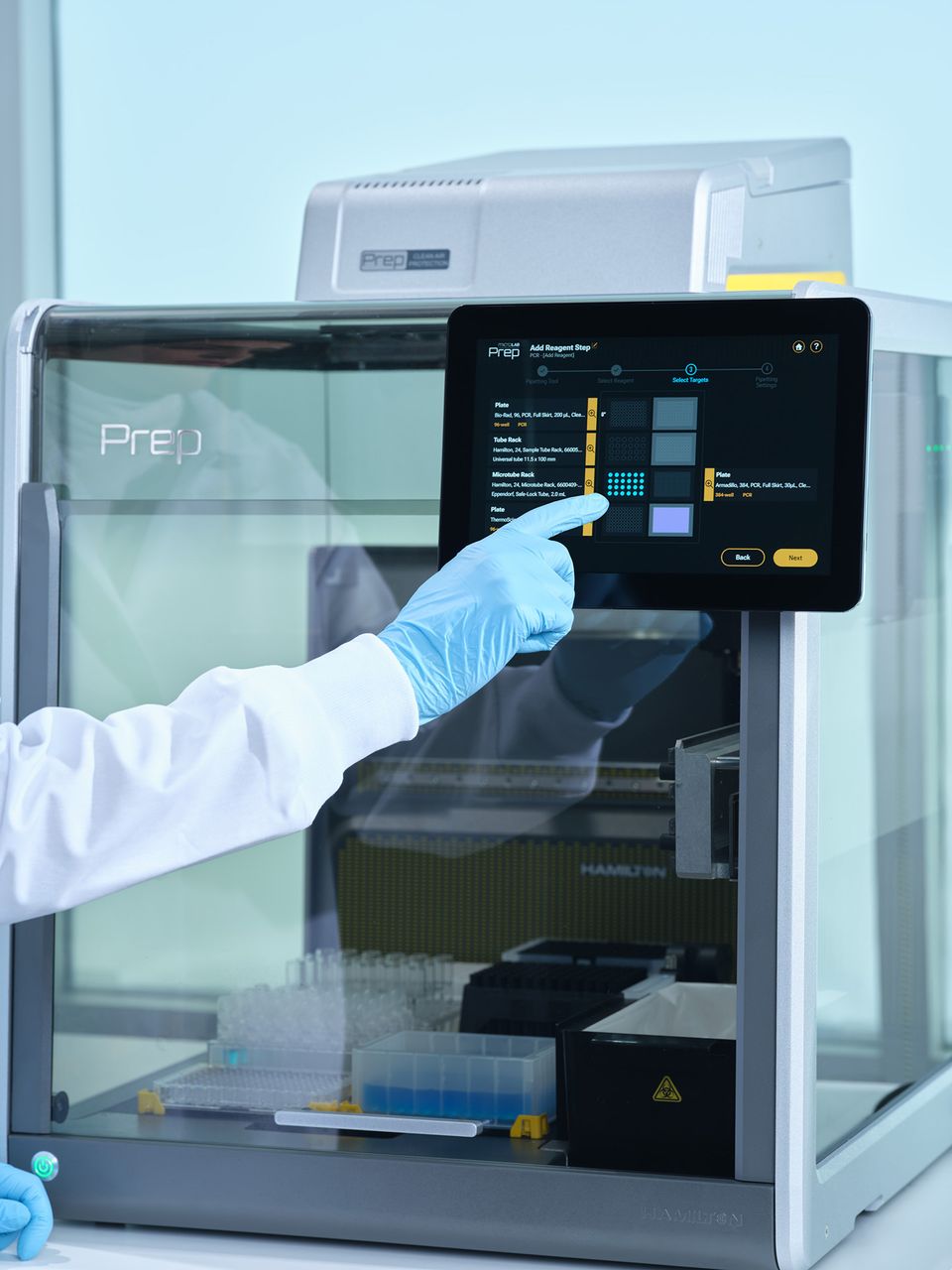 Gloved hand touching the touchscreen of a Hamilton Prep automated liquid handler showing an Add Reagent Step workflow